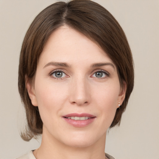 Joyful white young-adult female with medium  brown hair and grey eyes