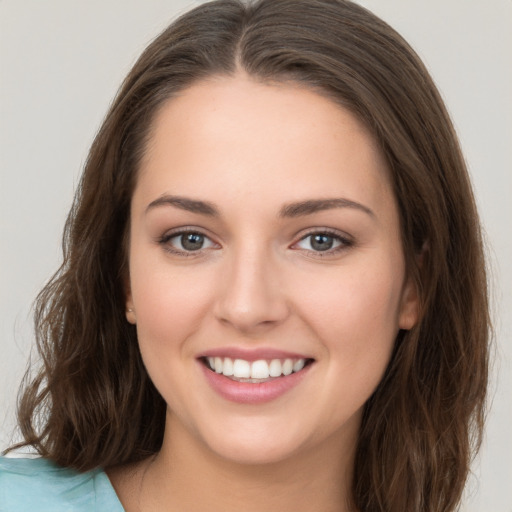 Joyful white young-adult female with long  brown hair and grey eyes