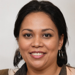 Joyful latino adult female with medium  brown hair and brown eyes