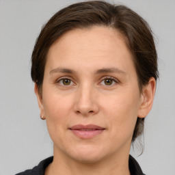 Joyful white adult female with medium  brown hair and grey eyes