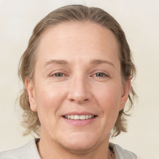 Joyful white adult female with medium  brown hair and grey eyes