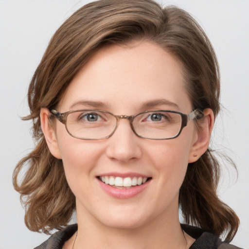 Joyful white young-adult female with medium  brown hair and blue eyes