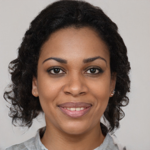 Joyful black young-adult female with medium  brown hair and brown eyes