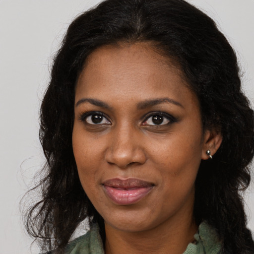 Joyful black young-adult female with long  brown hair and brown eyes