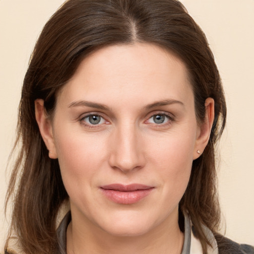 Joyful white young-adult female with medium  brown hair and grey eyes