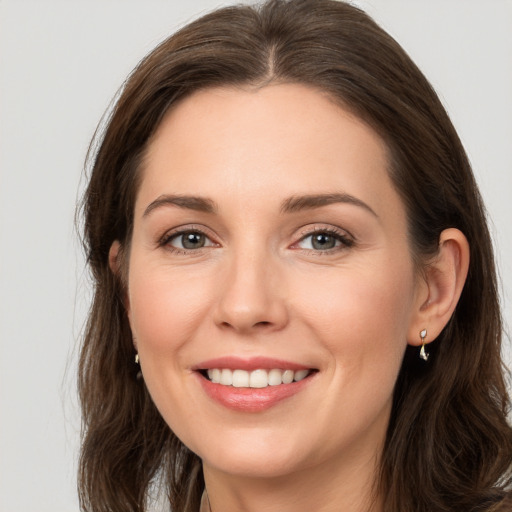 Joyful white young-adult female with long  brown hair and grey eyes