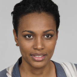 Joyful black young-adult female with short  black hair and brown eyes