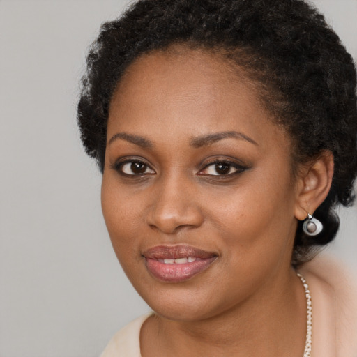 Joyful black young-adult female with long  brown hair and brown eyes