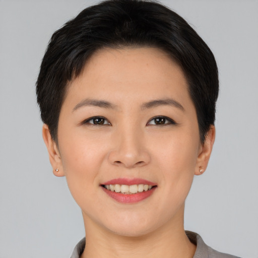 Joyful asian young-adult female with short  brown hair and brown eyes