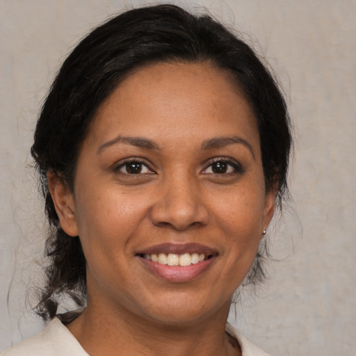 Joyful black adult female with medium  brown hair and brown eyes