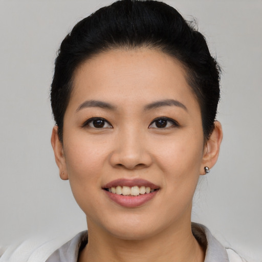 Joyful asian young-adult female with short  black hair and brown eyes