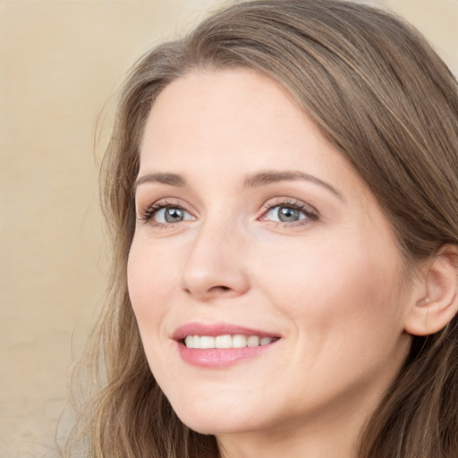 Joyful white young-adult female with long  brown hair and blue eyes