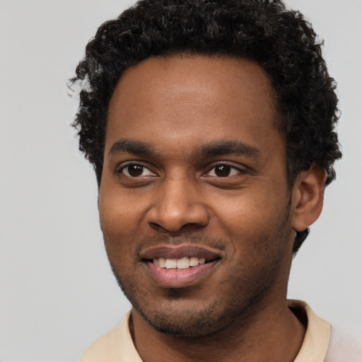 Joyful black young-adult male with short  black hair and brown eyes