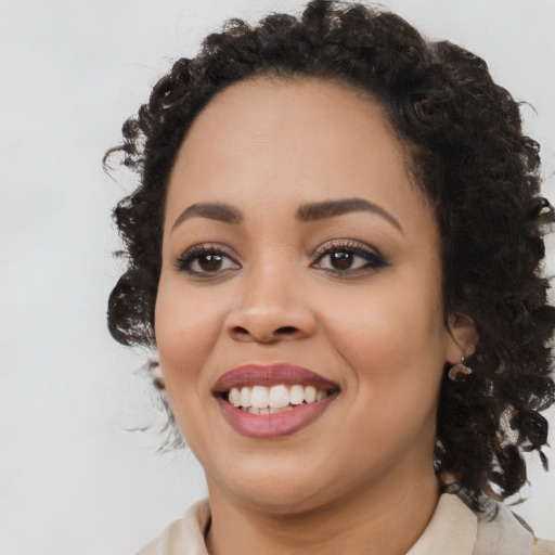 Joyful black young-adult female with long  black hair and brown eyes