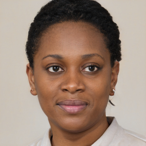 Joyful black young-adult female with short  black hair and brown eyes