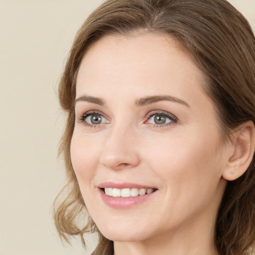 Joyful white young-adult female with long  brown hair and green eyes