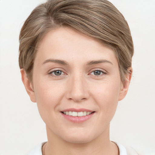 Joyful white young-adult female with short  brown hair and grey eyes