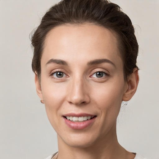 Joyful white young-adult female with short  brown hair and grey eyes