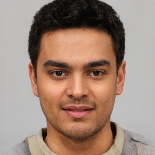 Joyful latino young-adult male with short  brown hair and brown eyes