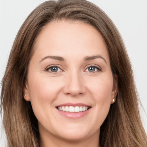 Joyful white young-adult female with long  brown hair and grey eyes