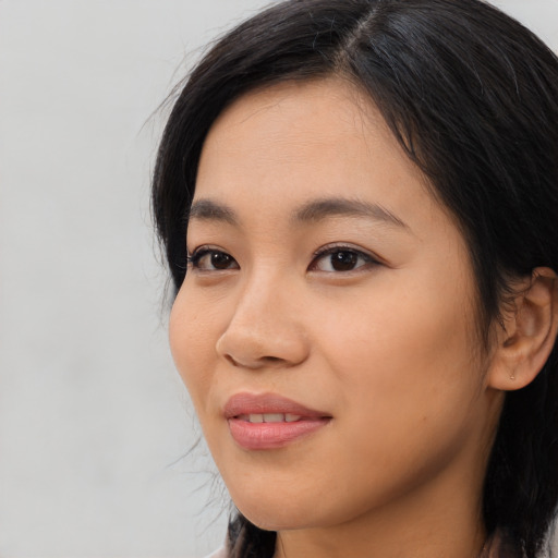 Joyful asian young-adult female with long  black hair and brown eyes