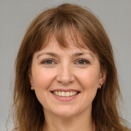 Joyful white adult female with long  brown hair and brown eyes