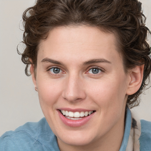 Joyful white young-adult female with medium  brown hair and blue eyes