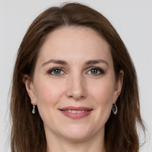 Joyful white adult female with long  brown hair and grey eyes