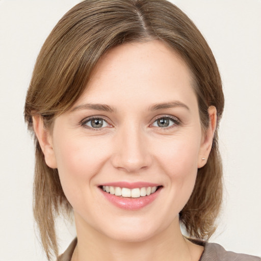 Joyful white young-adult female with medium  brown hair and grey eyes