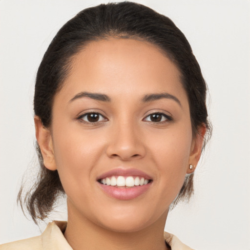 Joyful latino young-adult female with medium  brown hair and brown eyes