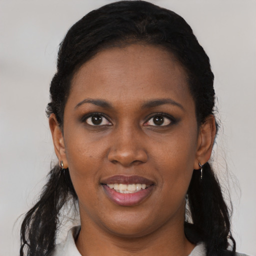 Joyful black young-adult female with long  black hair and brown eyes