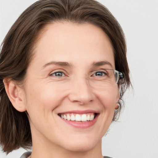 Joyful white adult female with medium  brown hair and grey eyes