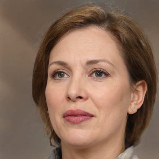 Joyful white adult female with medium  brown hair and grey eyes