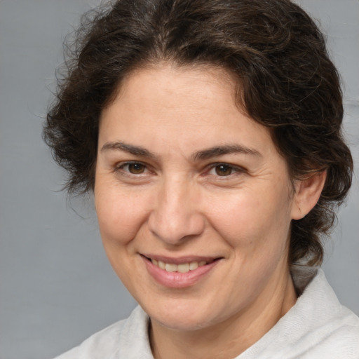 Joyful white adult female with medium  brown hair and brown eyes