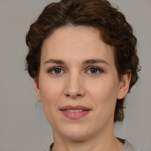 Joyful white young-adult female with medium  brown hair and green eyes