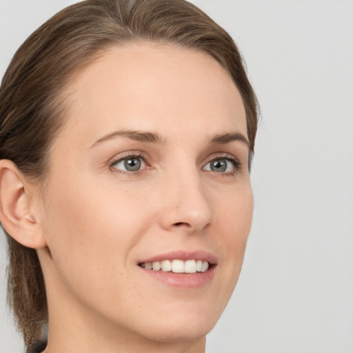 Joyful white young-adult female with medium  brown hair and grey eyes