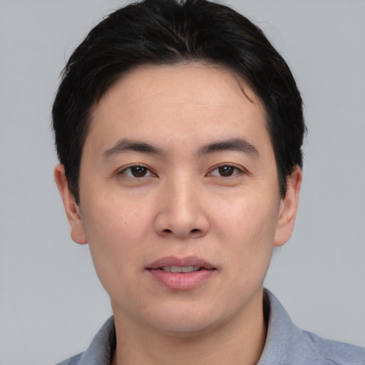 Joyful asian young-adult male with short  black hair and brown eyes