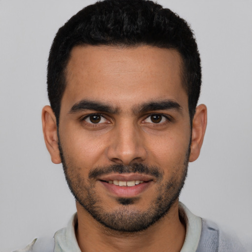 Joyful latino young-adult male with short  black hair and brown eyes