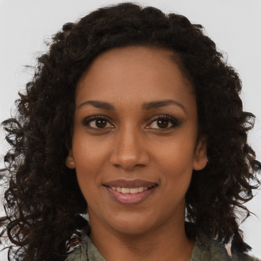 Joyful black young-adult female with long  brown hair and brown eyes