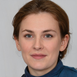 Joyful white young-adult female with medium  brown hair and blue eyes