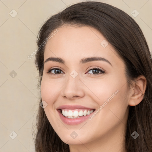 Joyful white young-adult female with long  brown hair and brown eyes