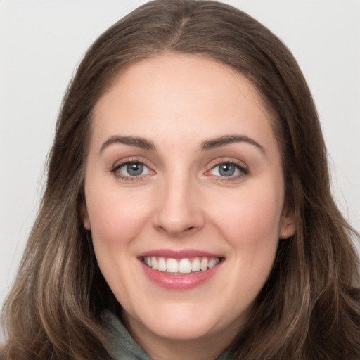 Joyful white young-adult female with long  brown hair and grey eyes