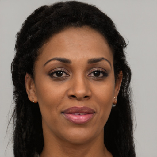 Joyful black young-adult female with long  brown hair and brown eyes