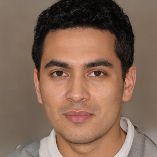 Joyful latino young-adult male with short  black hair and brown eyes