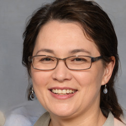 Joyful white adult female with medium  brown hair and blue eyes