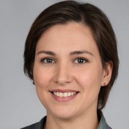 Joyful white young-adult female with medium  brown hair and brown eyes