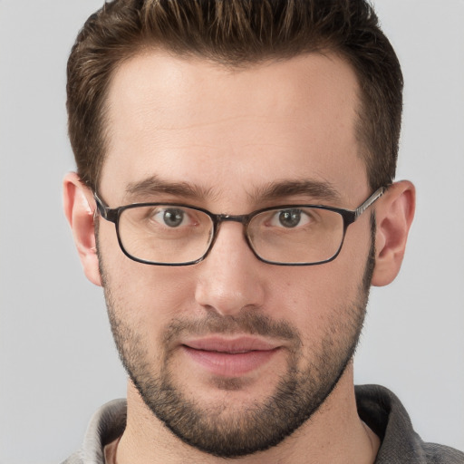 Joyful white young-adult male with short  brown hair and grey eyes