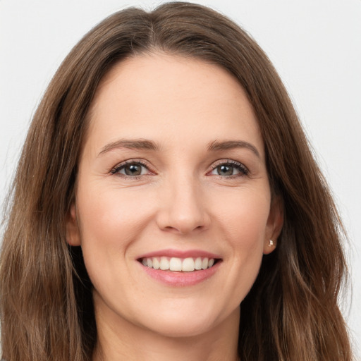 Joyful white young-adult female with long  brown hair and green eyes