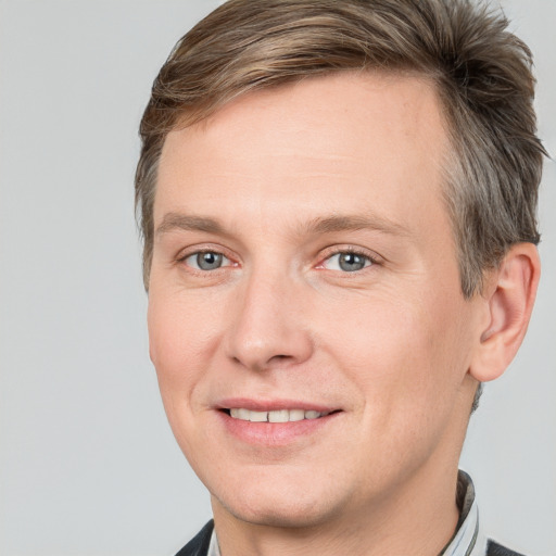 Joyful white adult male with short  brown hair and grey eyes