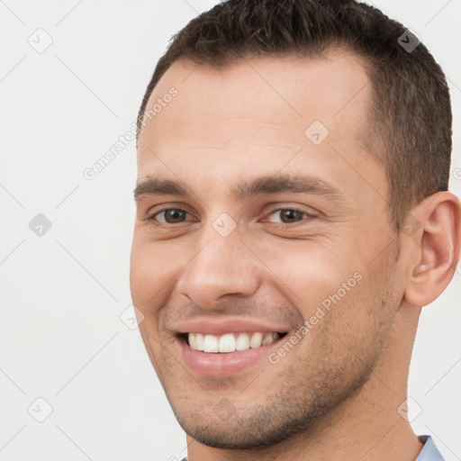 Joyful white young-adult male with short  brown hair and brown eyes